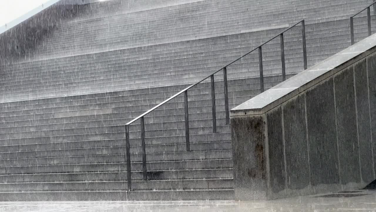 暴雨落在城市建筑物的楼梯上。视频下载