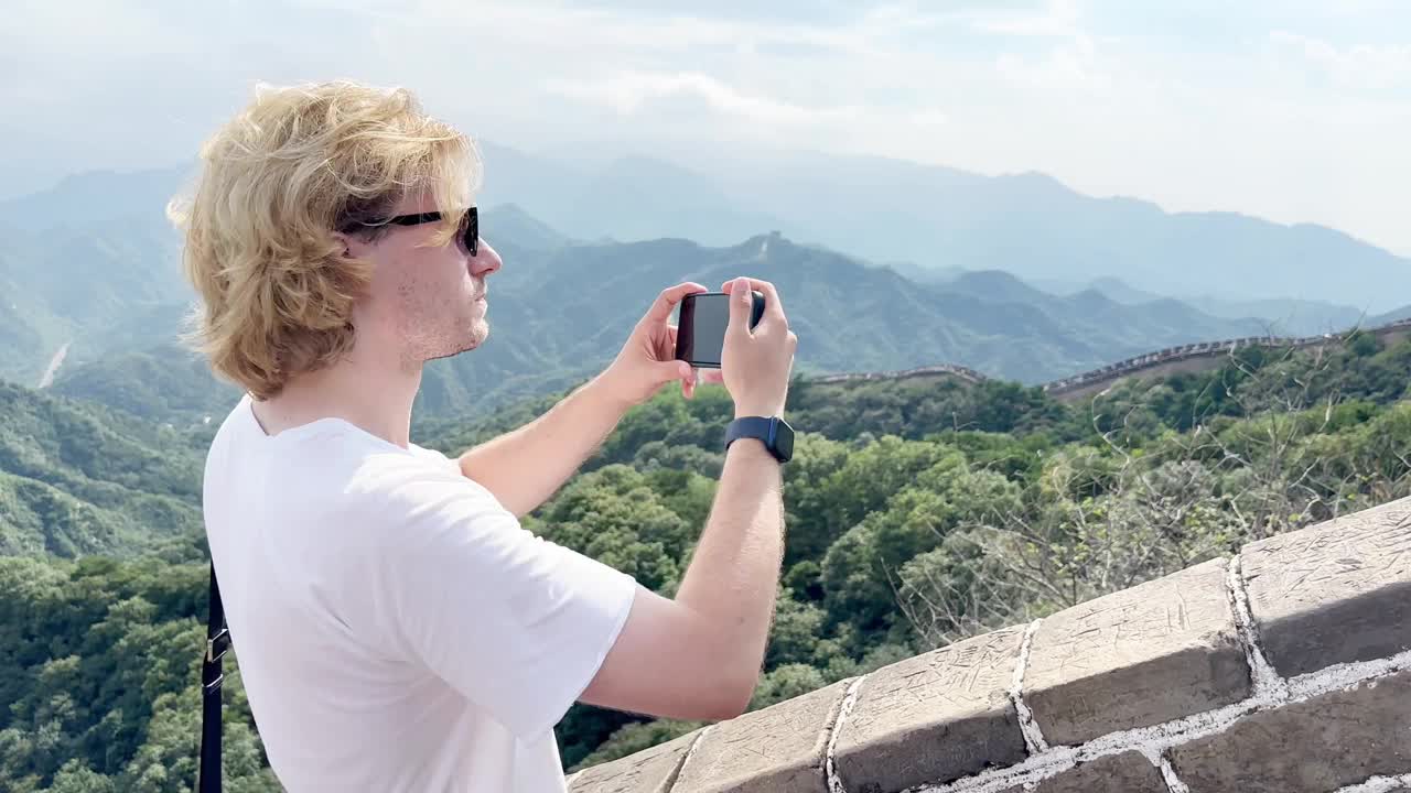 年轻人旅行时用智能手机拍摄视频和照片视频下载