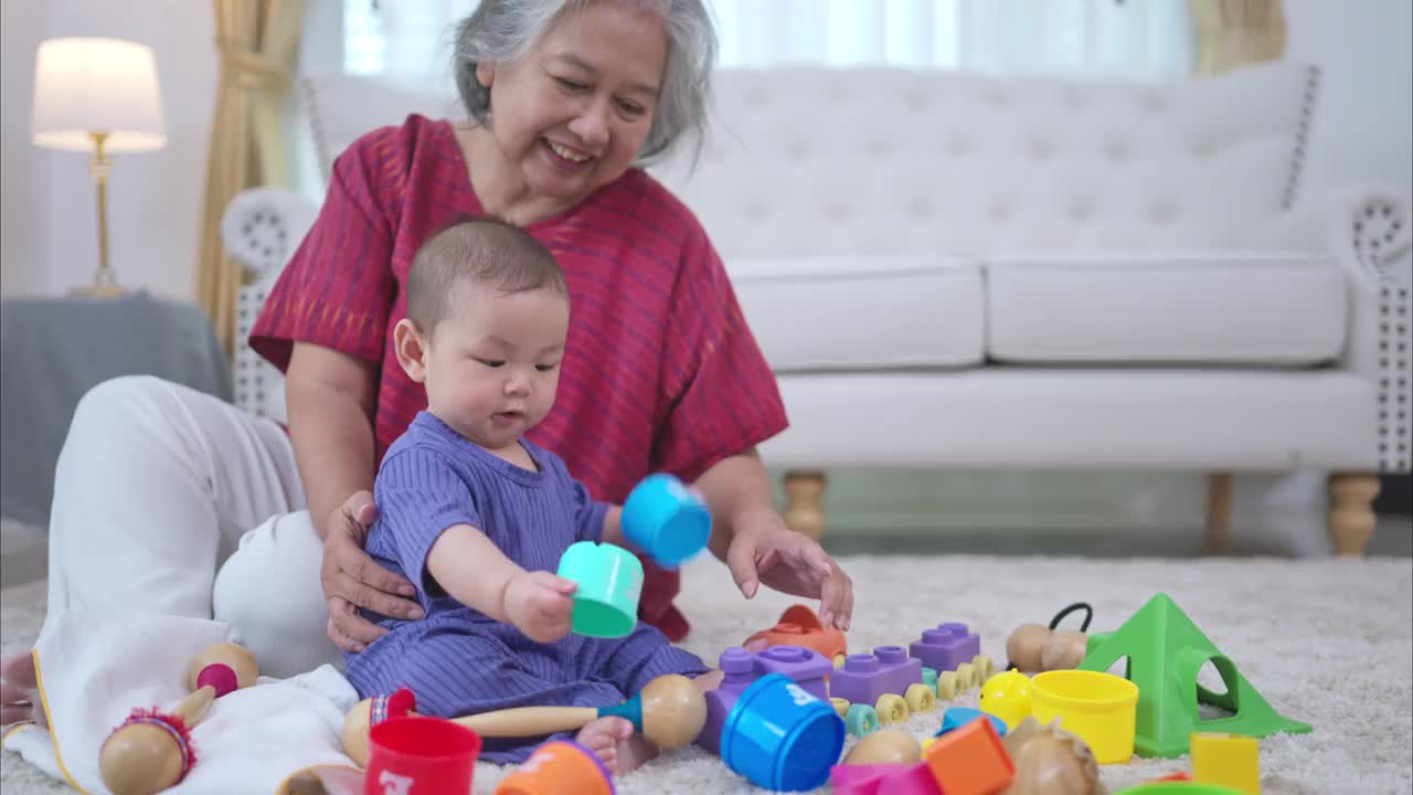 奶奶和他们的小孙子在房子的客厅里快乐地玩耍视频下载