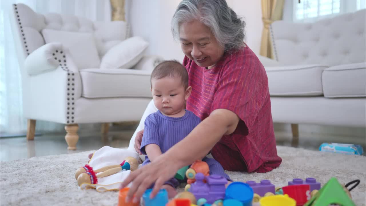 奶奶和他们的小孙子在房子的客厅里快乐地玩耍视频下载