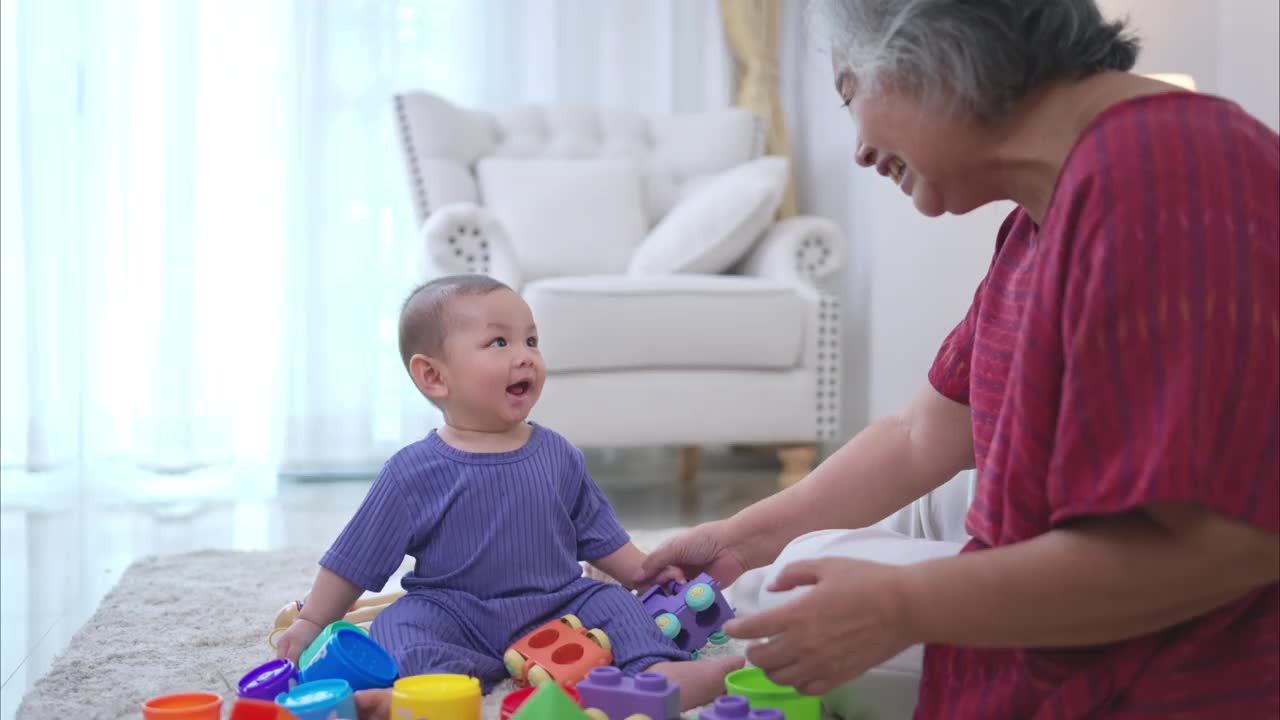 奶奶和他们的小孙子在房子的客厅里快乐地玩耍视频下载