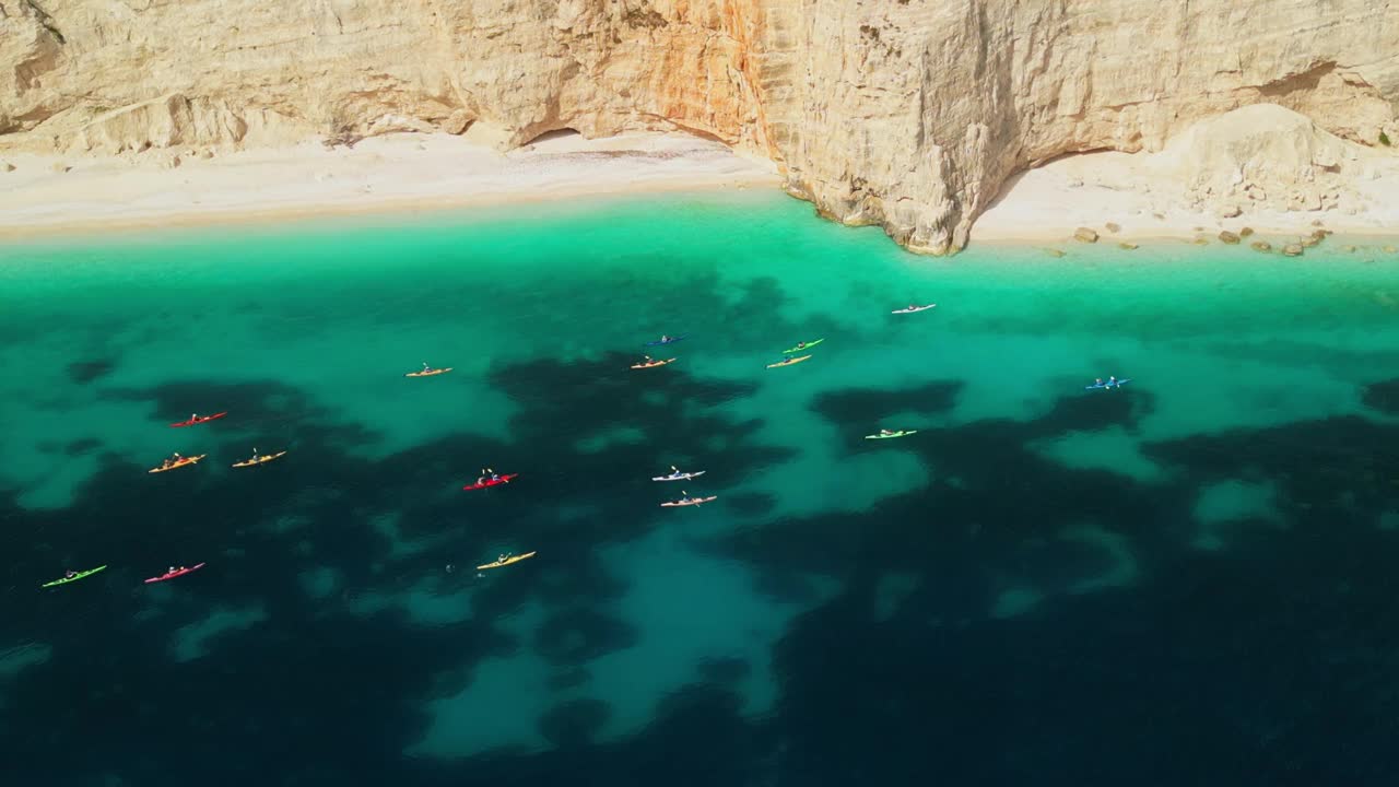 鸟瞰图，一群人在泻湖和美丽的海滩上乘坐皮划艇旅行视频素材