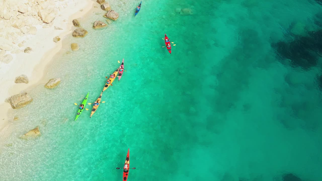 鸟瞰图，一群人在泻湖和美丽的海滩上乘坐皮划艇旅行视频素材