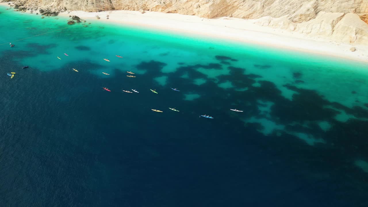 鸟瞰图，一群人在泻湖和美丽的海滩上乘坐皮划艇旅行视频下载