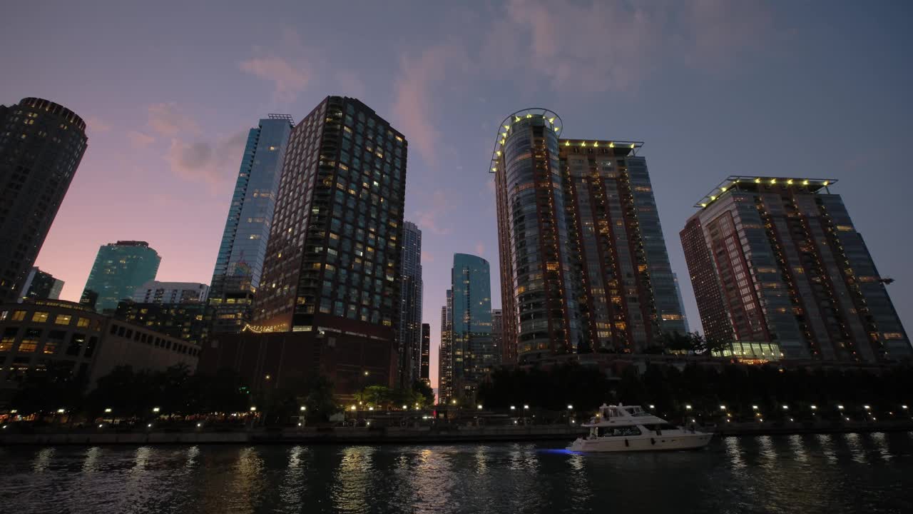 芝加哥市中心滨河步行街的夜景。充满活力的建筑和城市灯光在河上闪烁的倒影视频素材