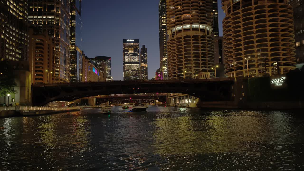 芝加哥市中心滨河步行街的夜景。充满活力的建筑和城市灯光在河上闪烁的倒影视频下载