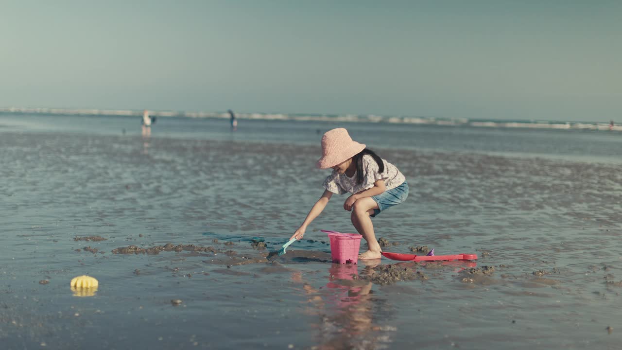 一个小女孩在夏天的海滩上玩耍视频素材