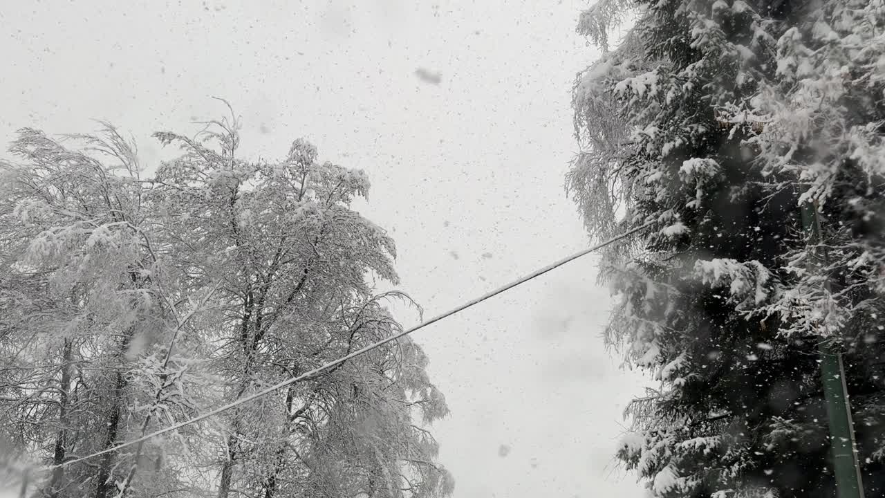 大雪花在暴风雪中落在汽车挡风玻璃上视频下载