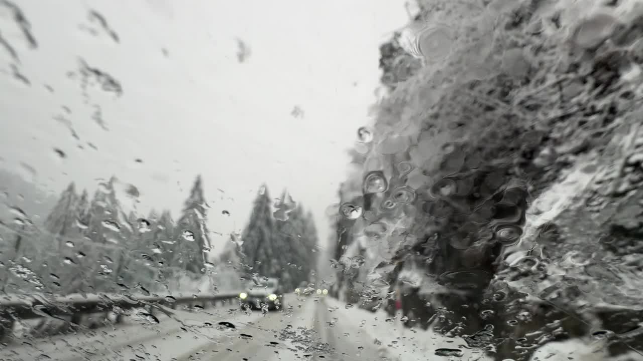 在暴风雪中行驶在覆盖着厚厚的积雪的山路上视频下载