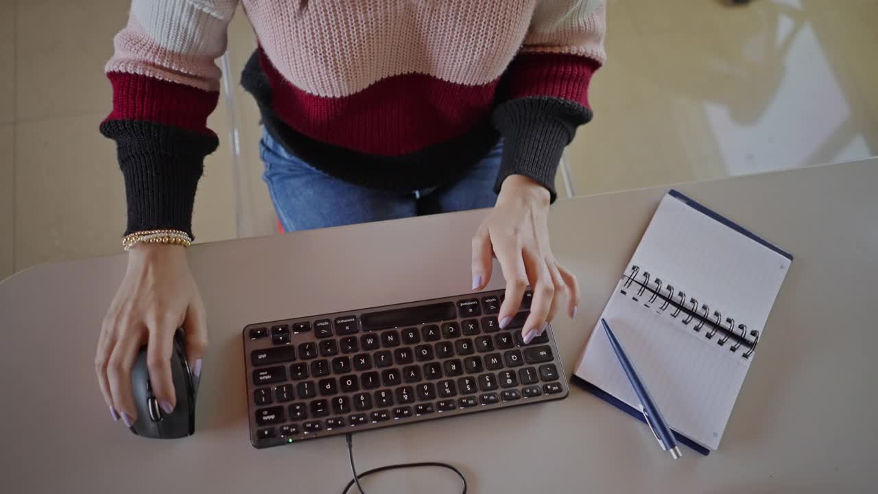 桌面视图，西班牙裔年轻女子在家里办公室用手在电脑键盘上打字视频下载