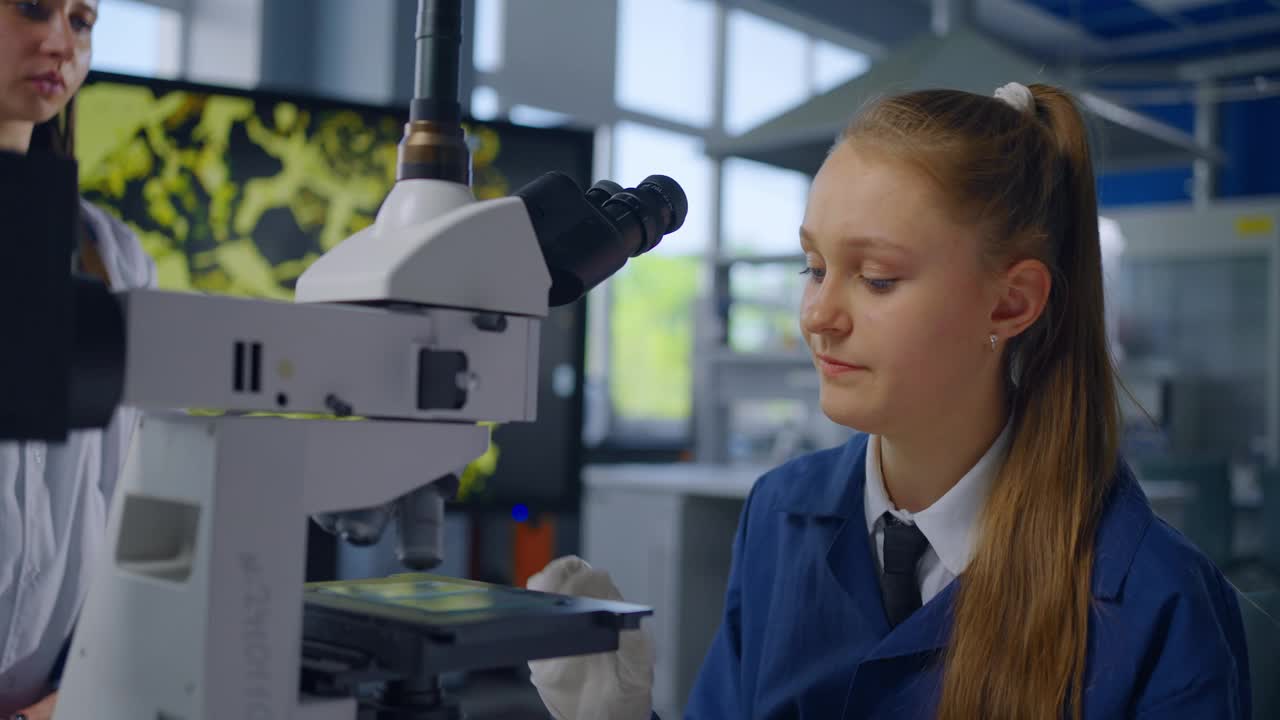 迷人的白人女学生在教室里用显微镜观察试剂，科学中的女性视频素材