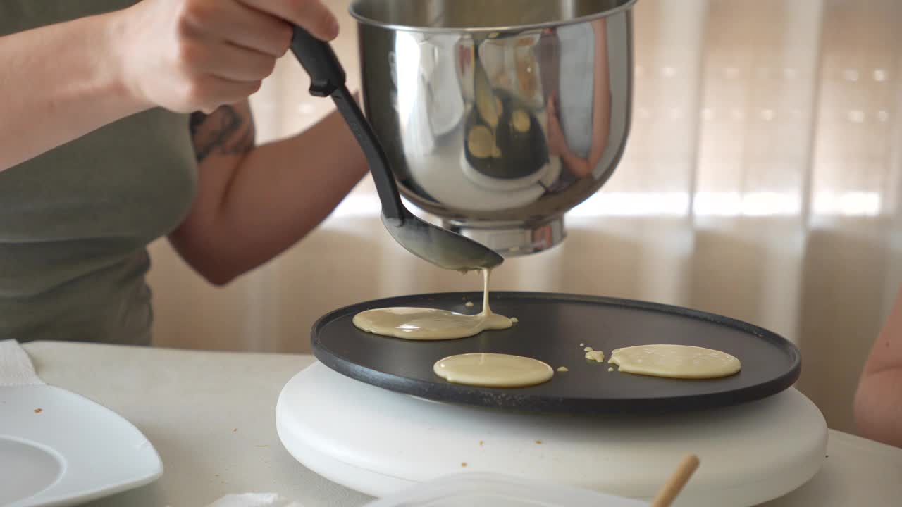 一个女人正在用平底锅做煎饼视频下载