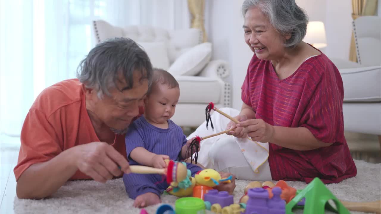 爷爷奶奶和他们的小孙子在房子的客厅里快乐地玩耍视频下载