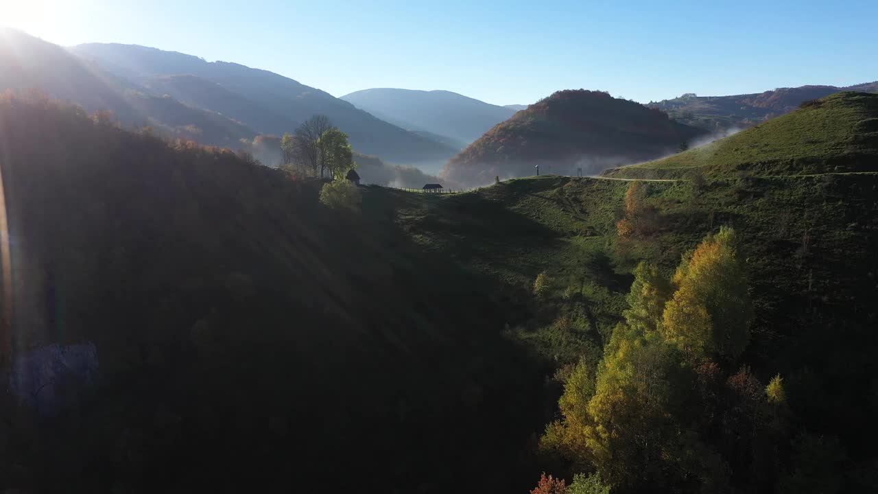 清晨鸟瞰乡村秋日薄雾缭绕的山丘视频下载