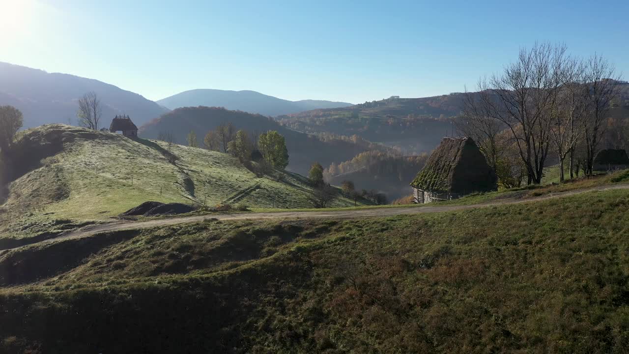 鸟瞰山间牧场，秋天茅草屋顶的木屋视频素材