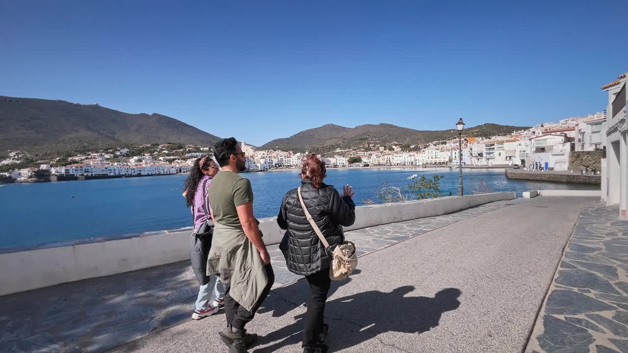 一群人沿着卡达夸斯湾的海岸散步，宁静的景色，西班牙加泰罗尼亚视频下载