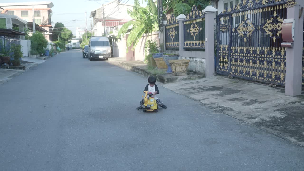 小男孩想象着开着推土机，一边玩一边练习用手臂肌肉铲沙子。视频素材