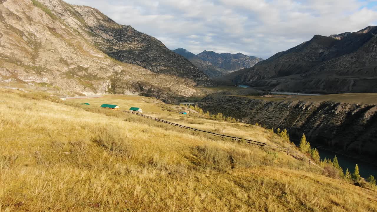 黄色的草地，山间的村庄，绿色的屋顶，木制的栅栏视频下载