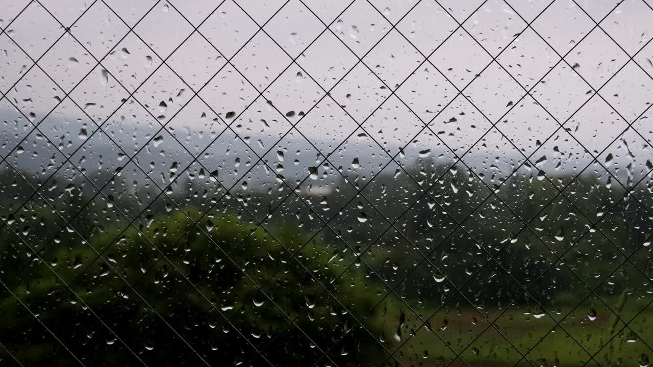 连绵的雨点，窗玻璃和雨点的特写，黑暗的气氛视频下载