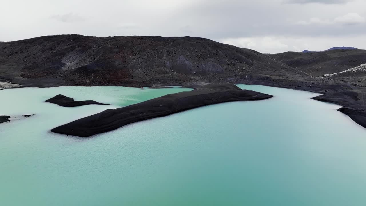 高山死气沉沉的湖泊，冰川和火山灰正在融化。冰岛荒凉的绿松石湖景观在一个阴天视频下载