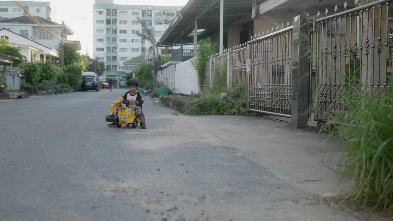 小男孩想象着开着推土机，一边玩一边练习用手臂肌肉铲沙子。视频下载