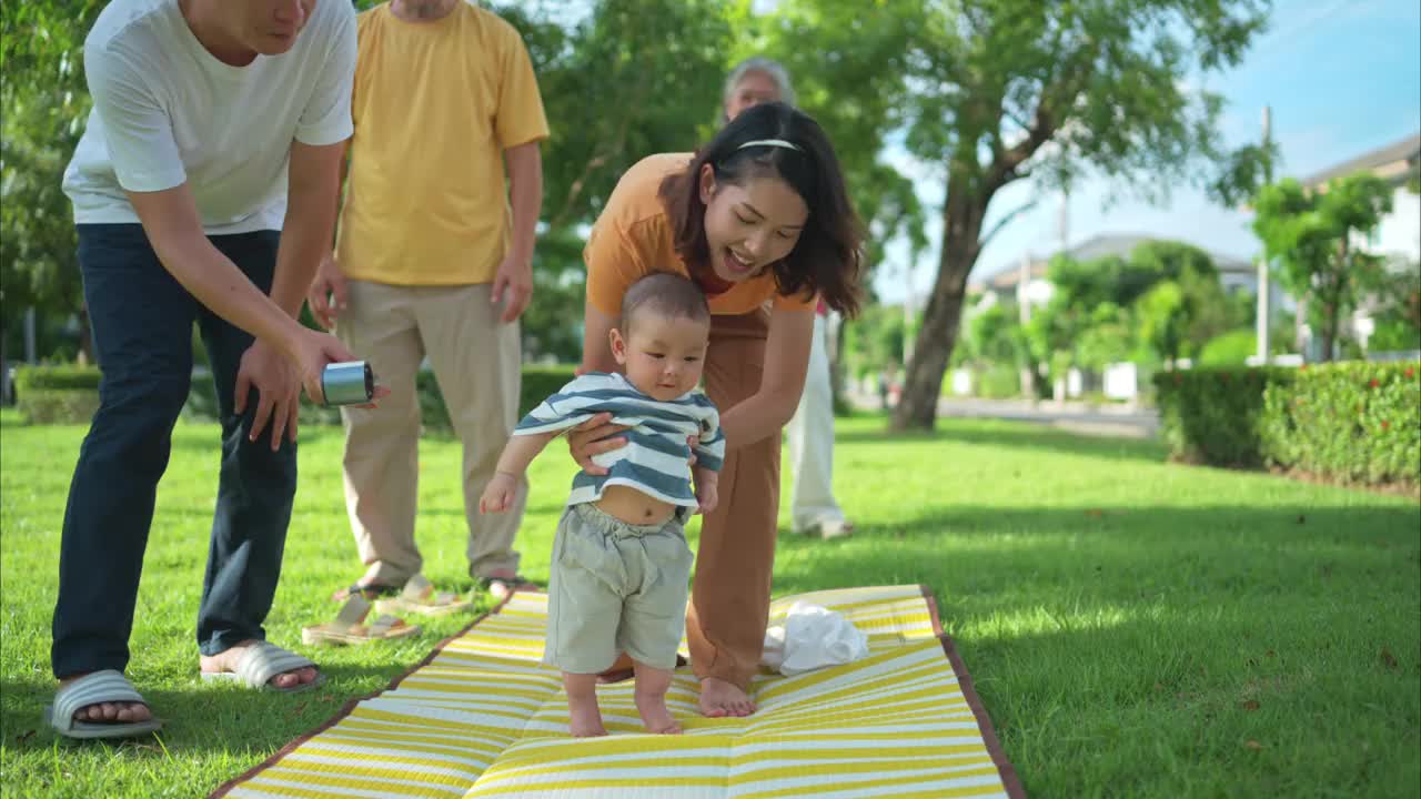 爷爷奶奶和带着小孩的父母正在公园里玩耍和休息视频下载