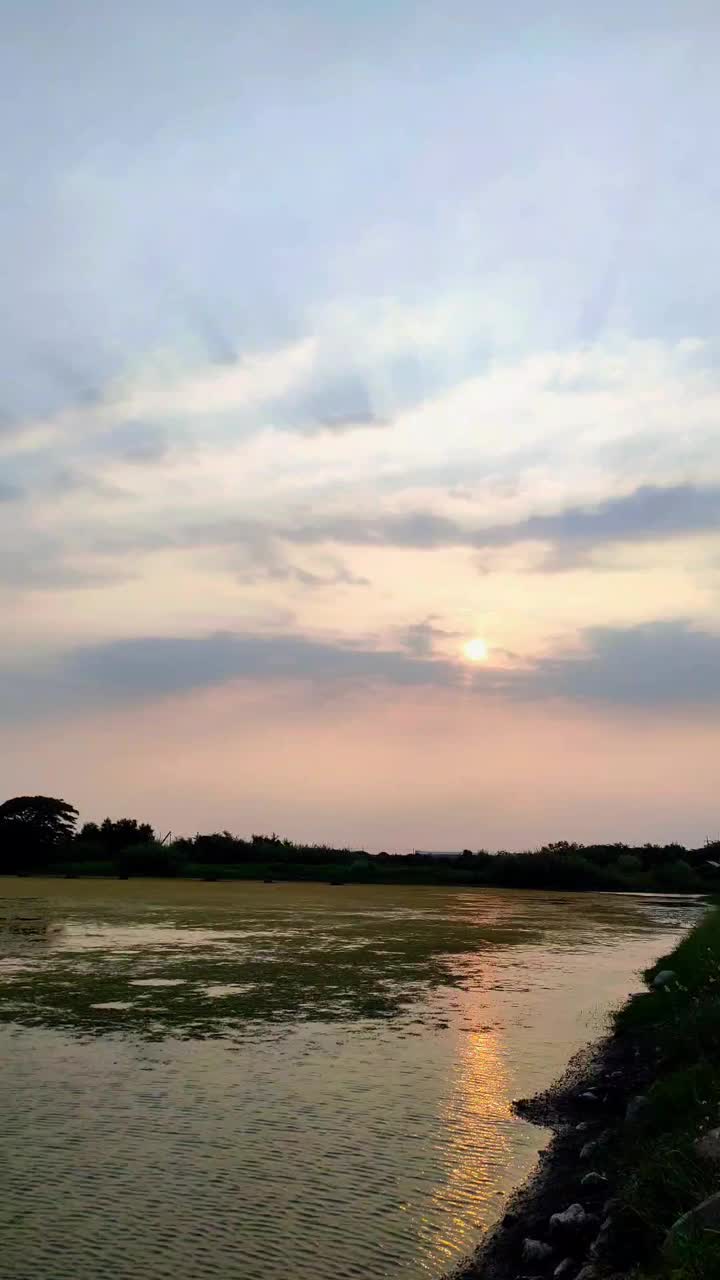 宁静的池塘上平静的日落，柔和的光线穿透云层视频素材