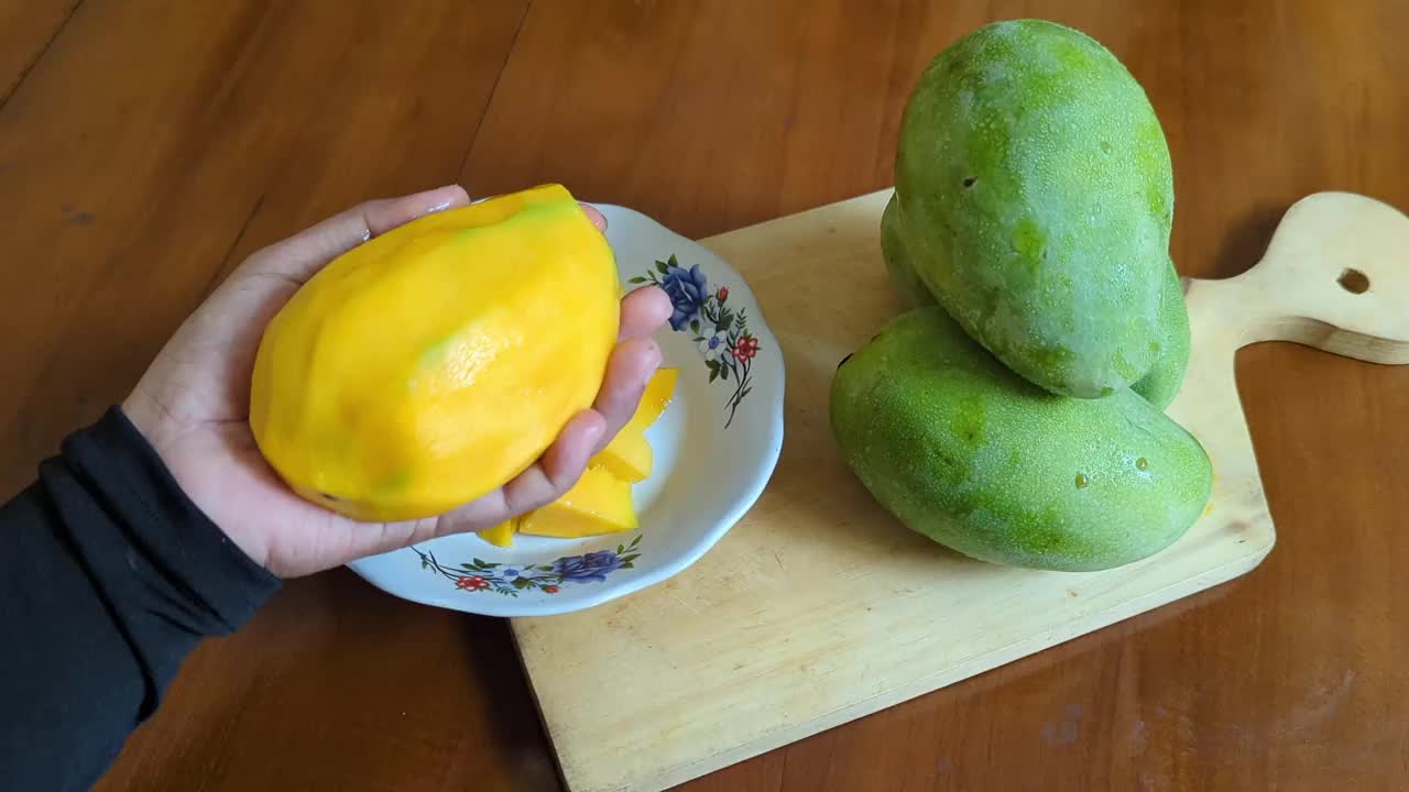 用刀切芒果块的手特写视频素材