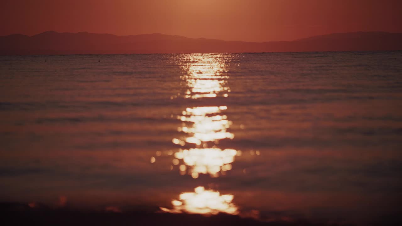 迷人的日落反射在一个宁静的大海在夏天，突出自然的美丽在黄金时间视频素材