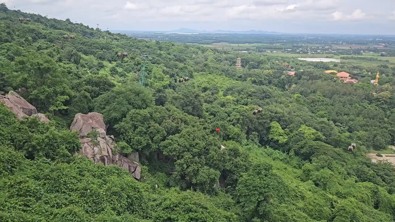 缆车沿着山坡在巴登山，Tay Ninh，越南。稻田和蓝天白云的背景。视频下载