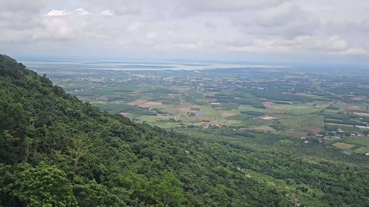 缆车沿着山坡在巴登山，Tay Ninh，越南。稻田和蓝天白云的背景。视频下载