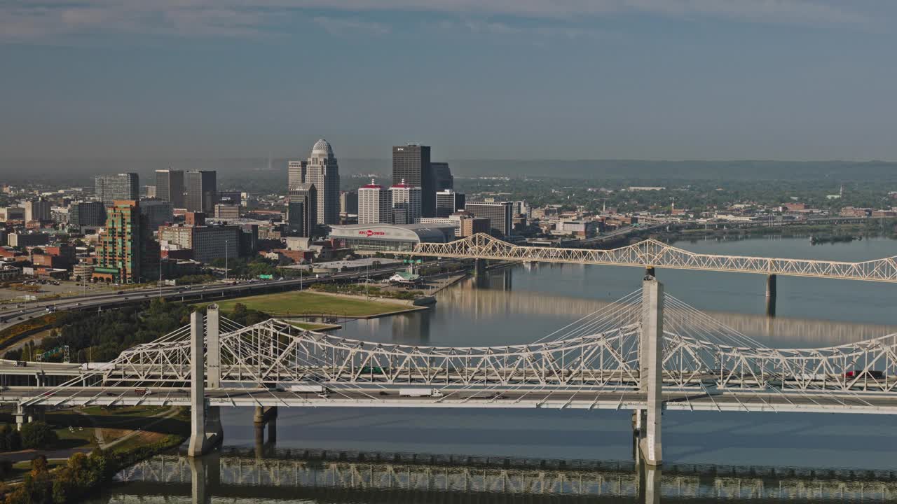 Louisville Kentucky Aerial v52无人机反向飞越俄亥俄河，河上有高速公路和人行天桥，市中心城市景观在天际线上的景色-使用Inspire 38k拍摄- 2023年9月26日视频素材