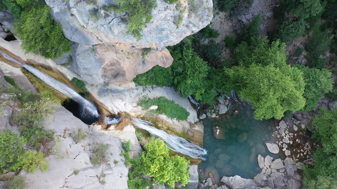 瀑布在绿树丛中高耸的山峰上壮丽的大自然中流淌，冰冷的水，从瀑布流下的水声宁静。周末度假的好去处。视频下载