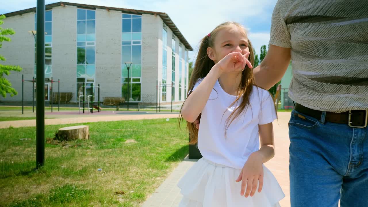 夏天，爷爷和他的小孙女在操场上玩耍。视频素材