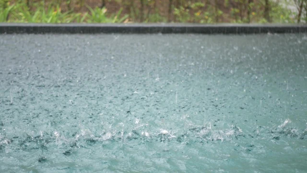 夏季，在泳池别墅度假区，雨水滴入私人泳池时，泳池内的水面一览无余视频下载