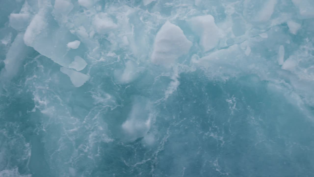 气势磅礴的破冰船在极地冰的慢动作，捕捉近距离的冰和雪碎片分散戏剧性视频素材