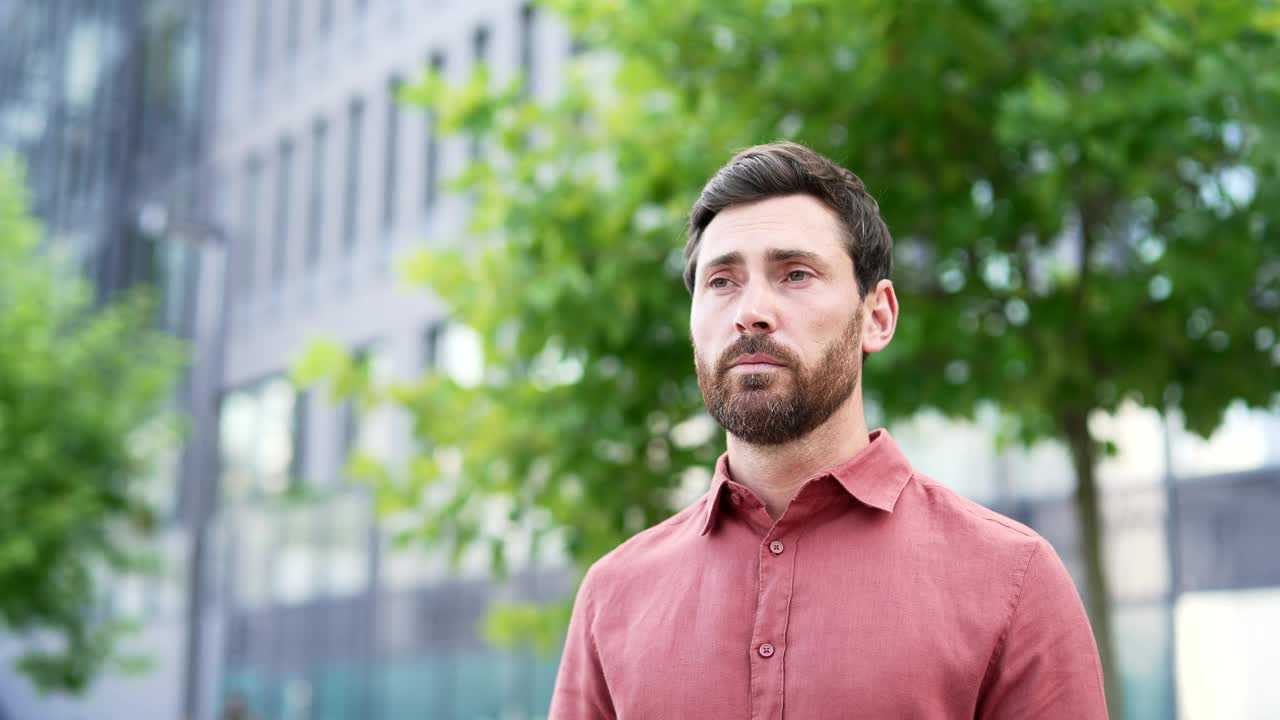 有过敏症状的男子站在城市室外时对着纸巾打喷嚏。视频下载