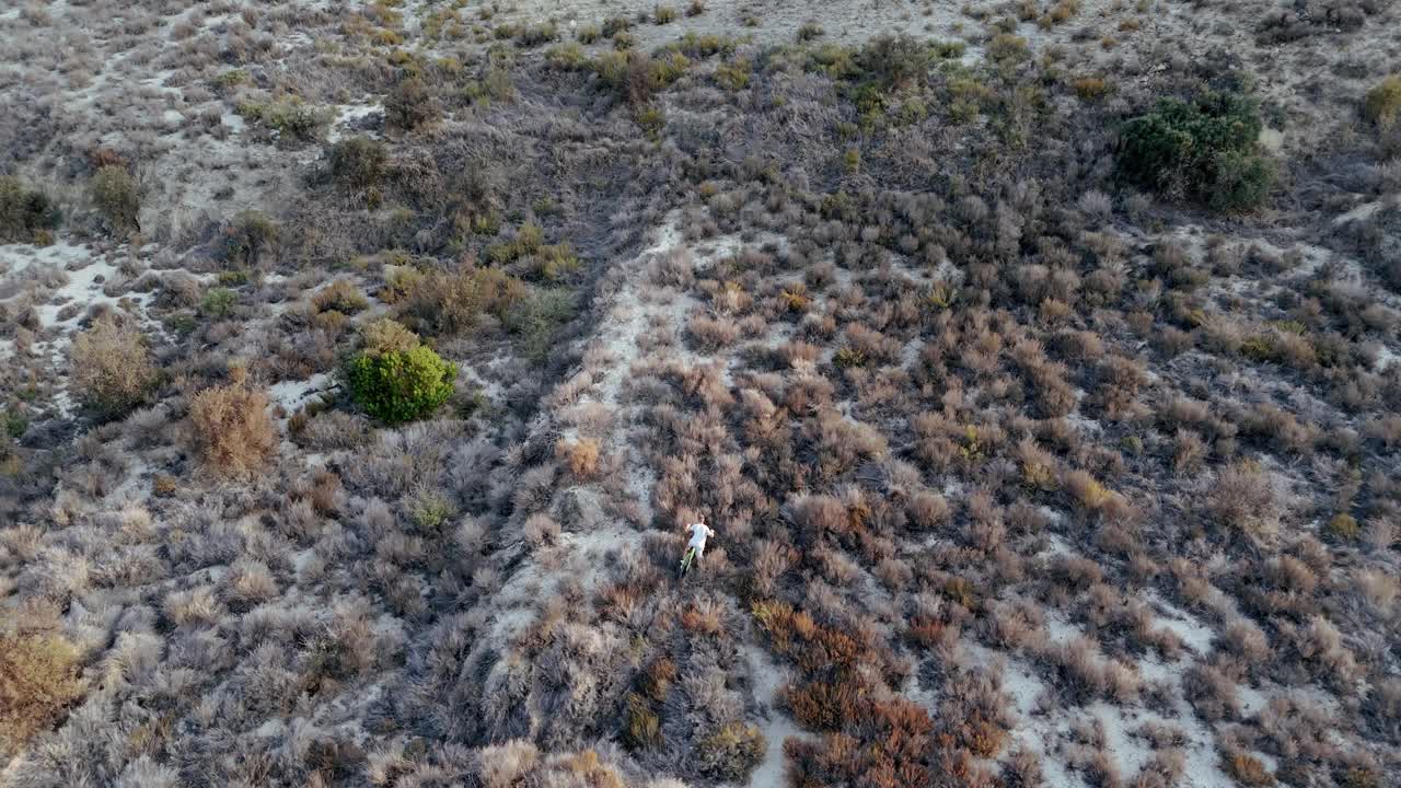 空中飞行。无人机电影镜头骑自行车的人沿着山脊，享受风景和挑战。鸟瞰美丽的山景视频下载