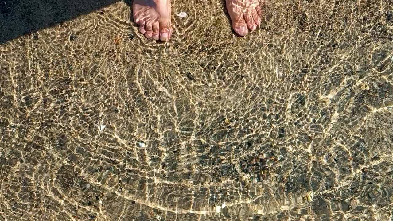 自然平静的大海背景。闪闪发光的海水和金色的沙子。夏日热带海滩上的海浪。阳光反射在水面上。浅浅的海水泛起涟漪。海床上的阳光。视频素材