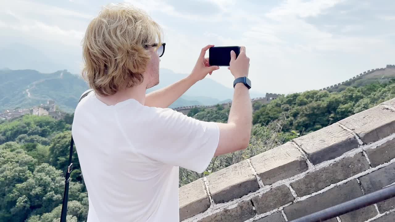 年轻人旅行时用智能手机拍摄视频和照片视频素材