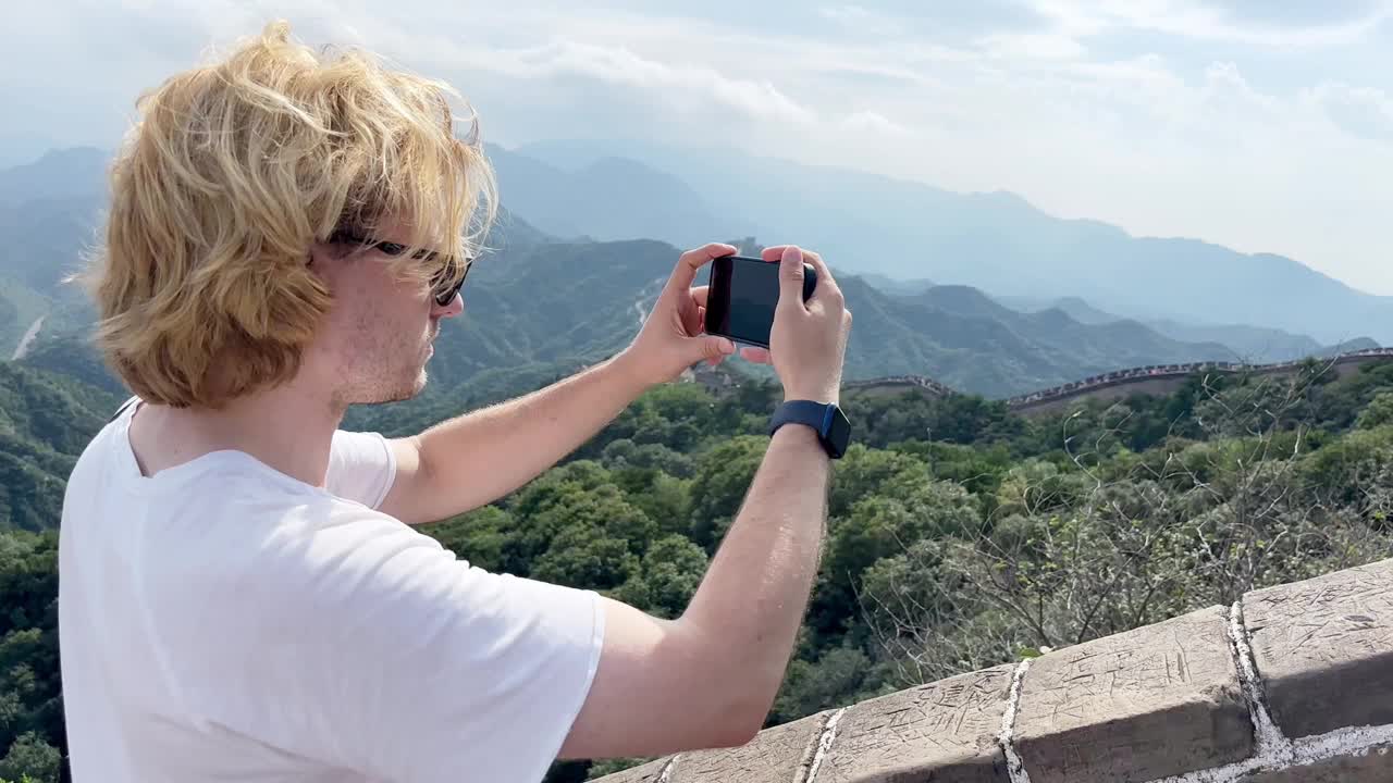 年轻人旅行时用智能手机拍摄视频和照片视频下载