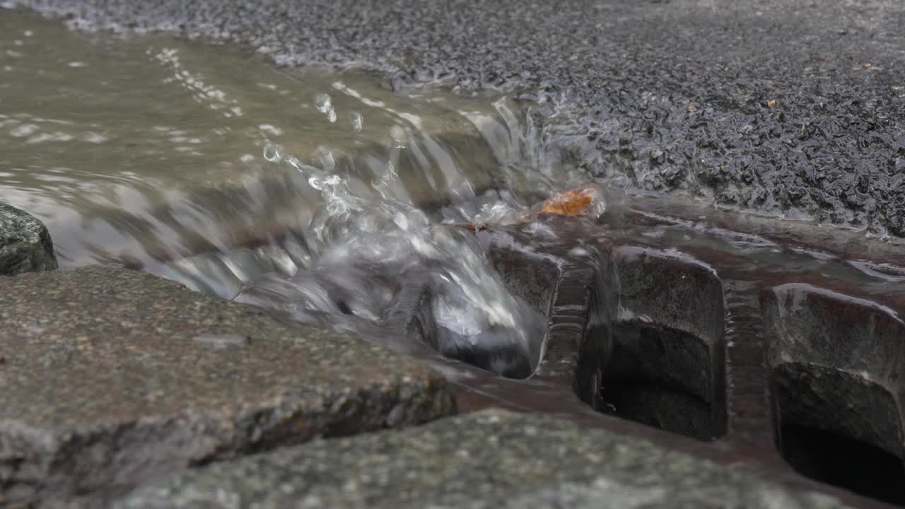 沿有强水流道路的排水沟和下水道格栅。视频素材