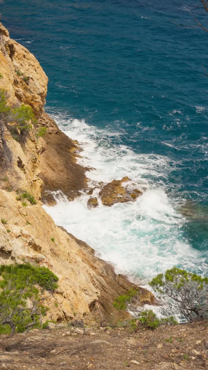 一个宁静的白色海浪打破了一个崎岖的，岩石海岸-高角度拍摄视频素材