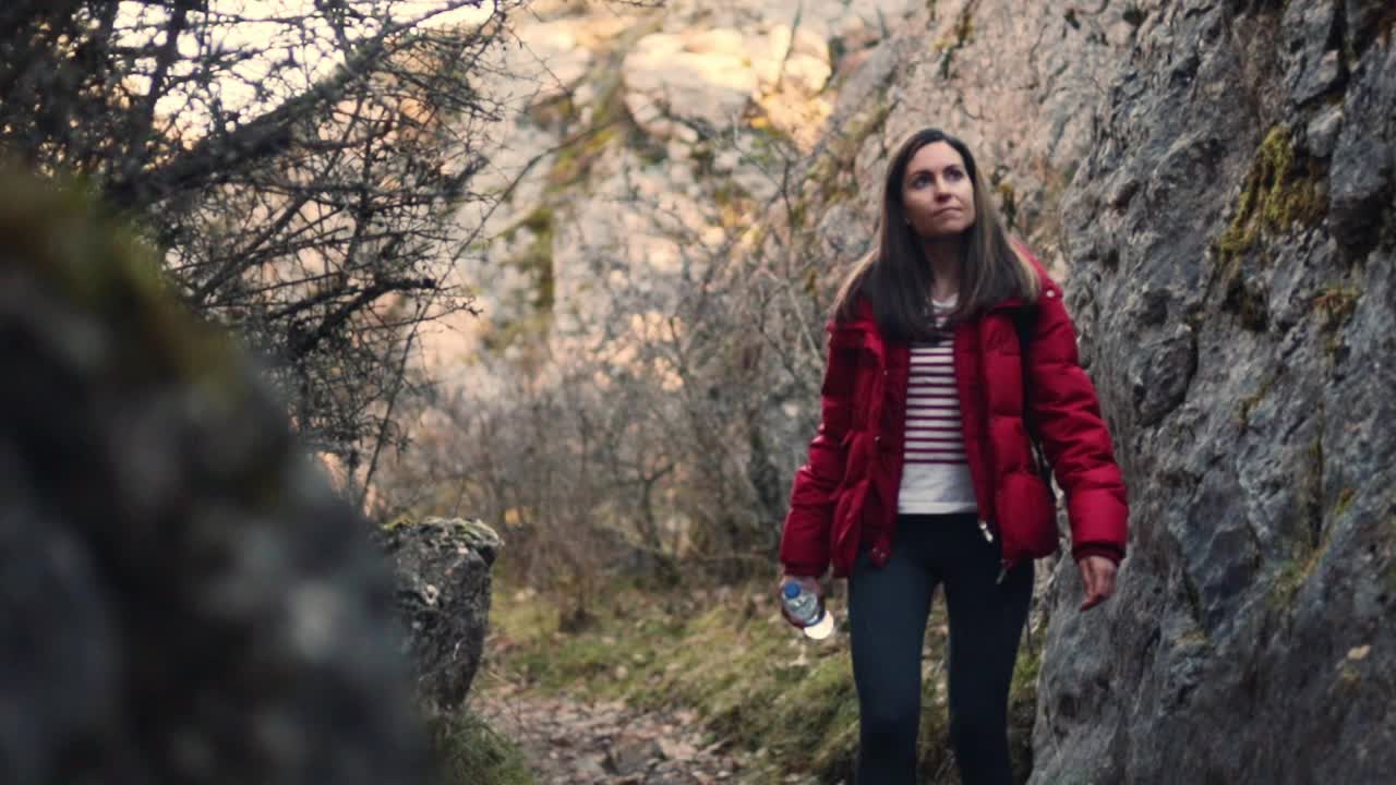 漂亮的白人女人在大自然中徒步旅行，欣赏大自然。慢动作，选择性聚焦。视频下载