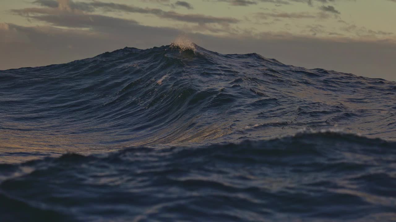 在温暖的午后阳光下，特写独特的强大海浪在海洋中破碎视频素材