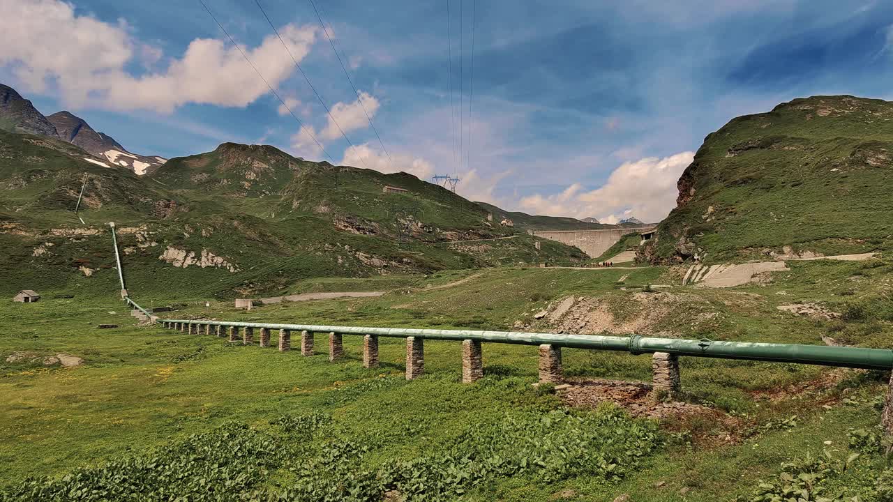 风景优美的夏天的绿色山谷与管道和山的背景视频素材