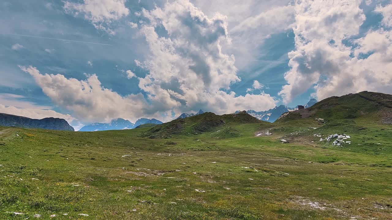 雄伟的高山景观与郁郁葱葱的草地在多云的天空下完美的自然主题设计项目视频素材