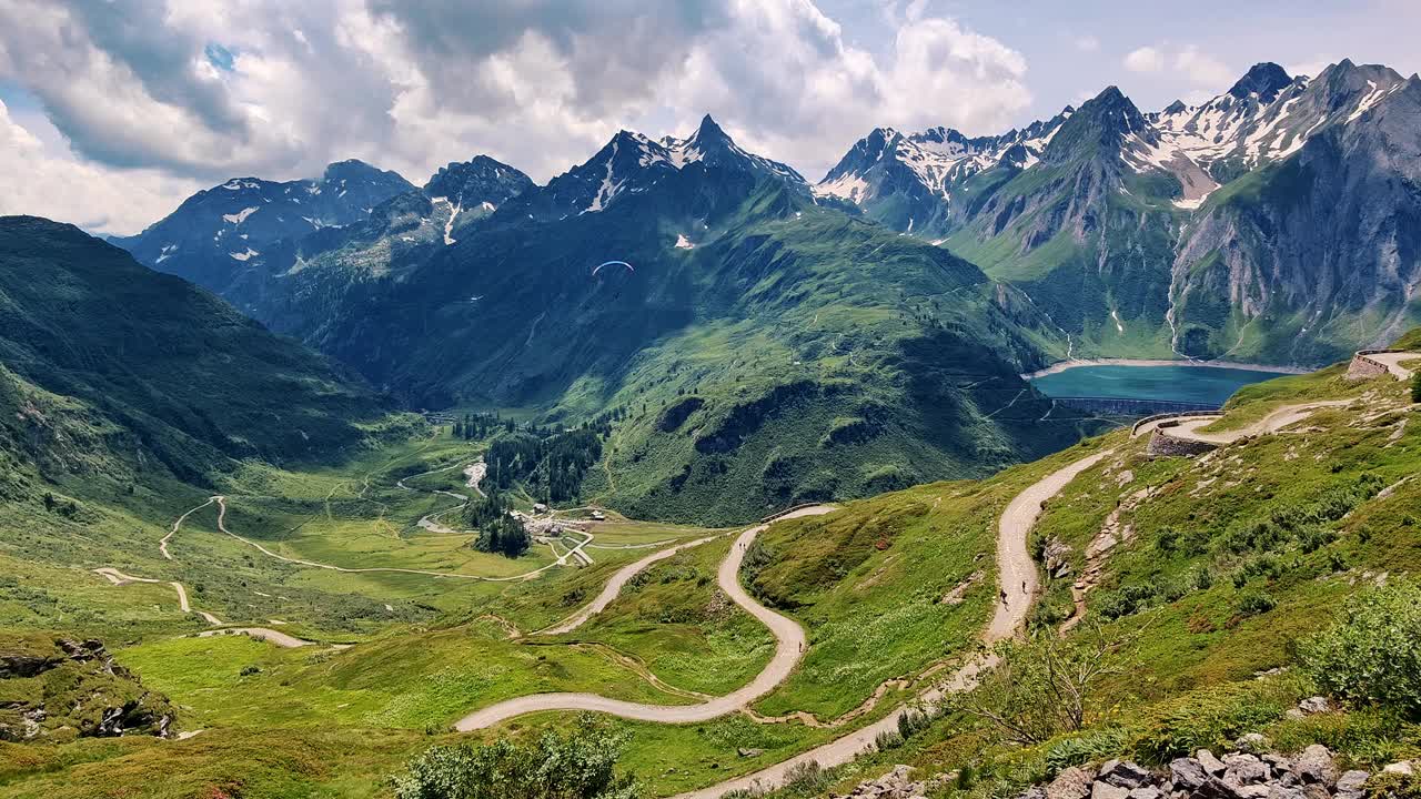 风景优美的高山景观，蜿蜒的道路和郁郁葱葱的绿色植物围绕着一个山湖视频素材