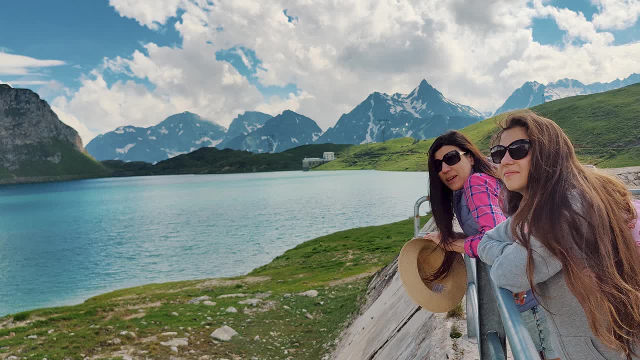 夏日出游时，朋友们在山上欣赏美丽的湖景视频下载