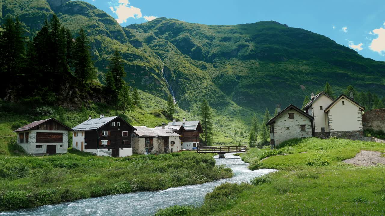 田园诗般的高山村庄与流动的河流和郁郁葱葱的青山完美的旅游海报视频素材